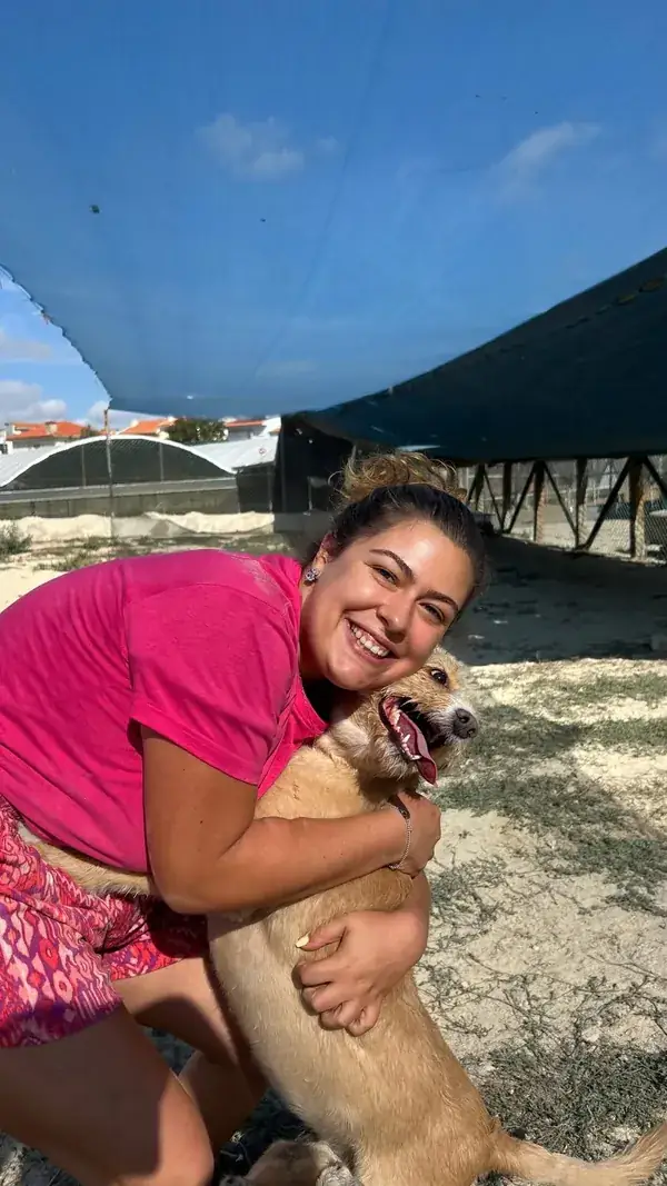 Colaboradora a abraçar um cão da creche